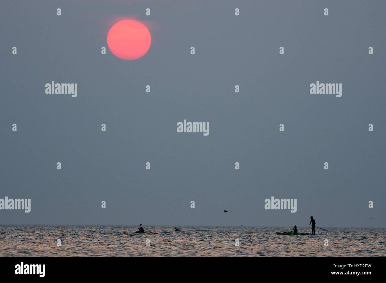 Aberystwyth, Wales, UK. 27. März 2017. UK-Wetter: Menschen paddle-Boarding und Kajakfahren auf das flache Meer bei Sonnenuntergang an der Cardigan Bay, Wales, am letzten Abend warme Schönwetterperiode bevor unruhige und feuchtere Bedingungen in den nächsten Tagen im Rollen Bildnachweis: Keith Morris/Alamy Live News Stockfoto