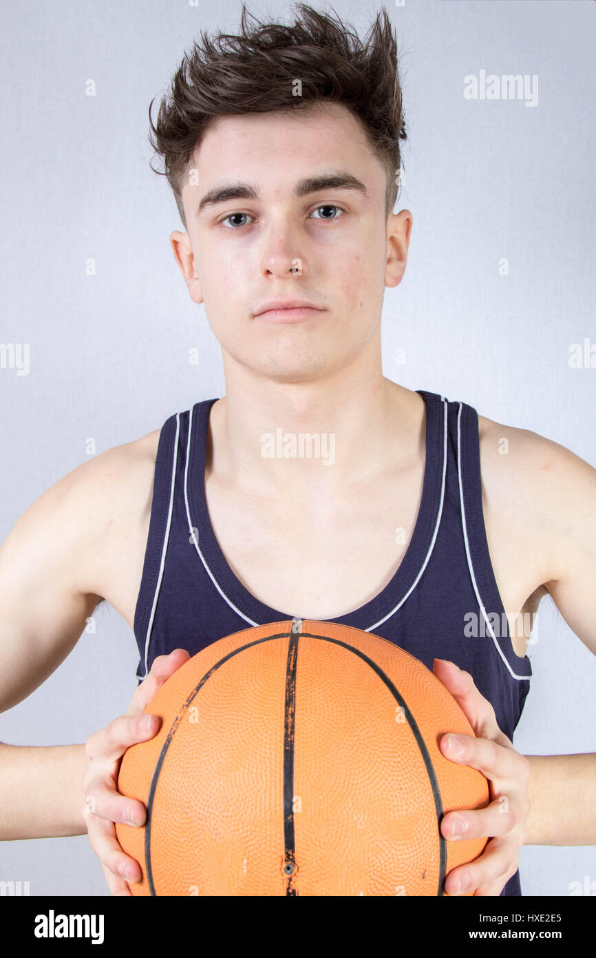 Kaukasische Teenager halten einen Basketball isoliert Stockfoto