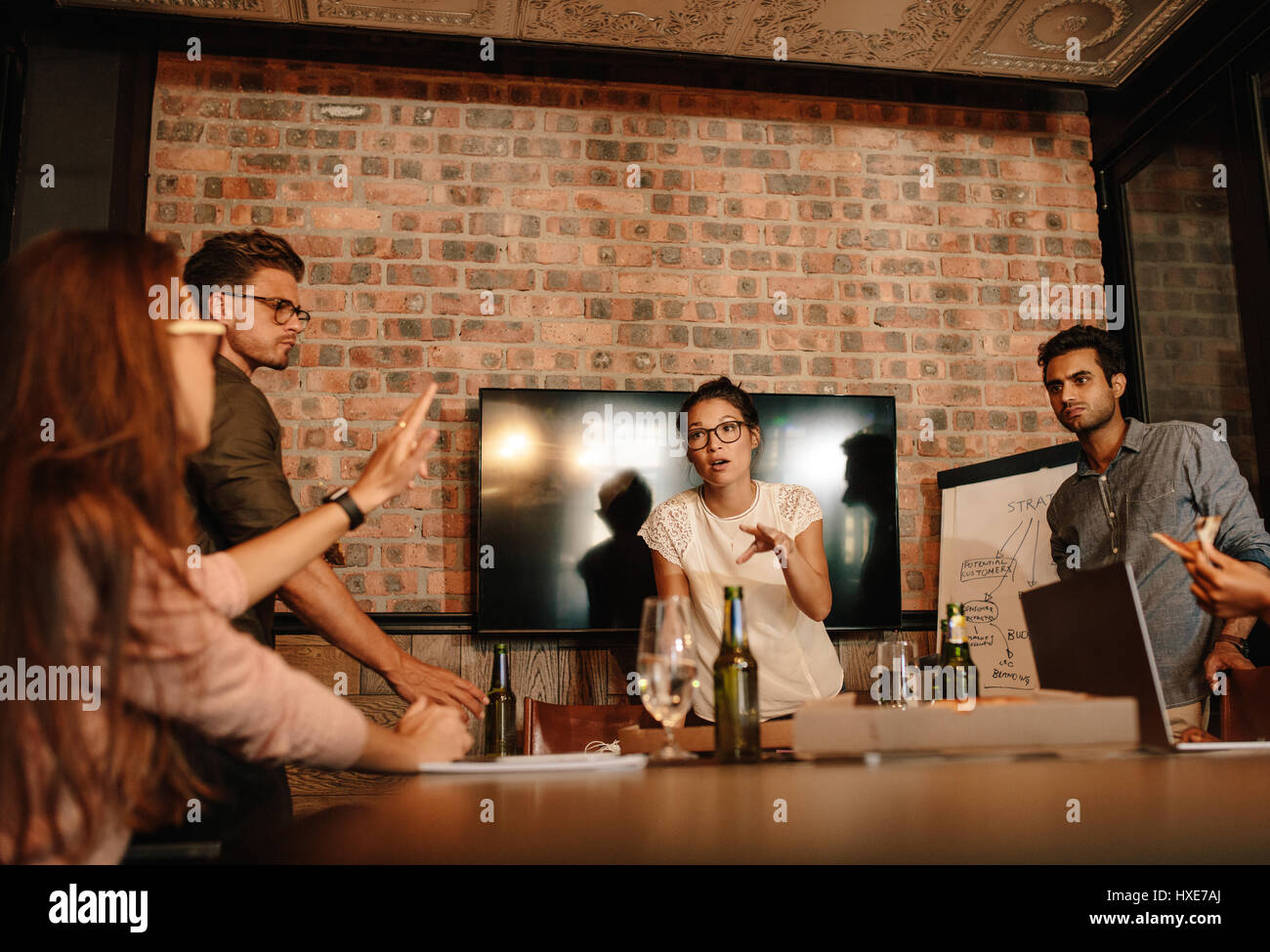 Gruppe von jungen Geschäftsleute mit einem treffen. Heterogene Gruppe von Menschen treffen in Startup Büro Konferenzraum. Stockfoto
