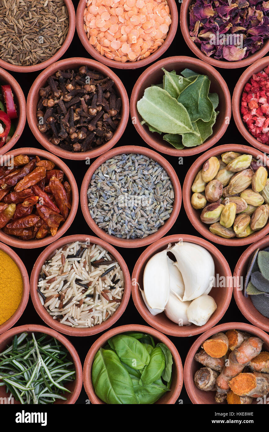 Zutaten zum Kochen. Kräuter, Gewürze, Nüsse, Samen und Hülsenfrüchten in runde Terracotta Töpfen Muster Stockfoto