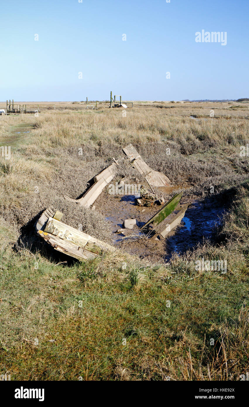 Überreste eines alten Fischerbootes, das in Salzmarschen an der Nordnorfolkküste in Thornham, Norfolk, England, Vereinigtes Königreich verrottet. Stockfoto