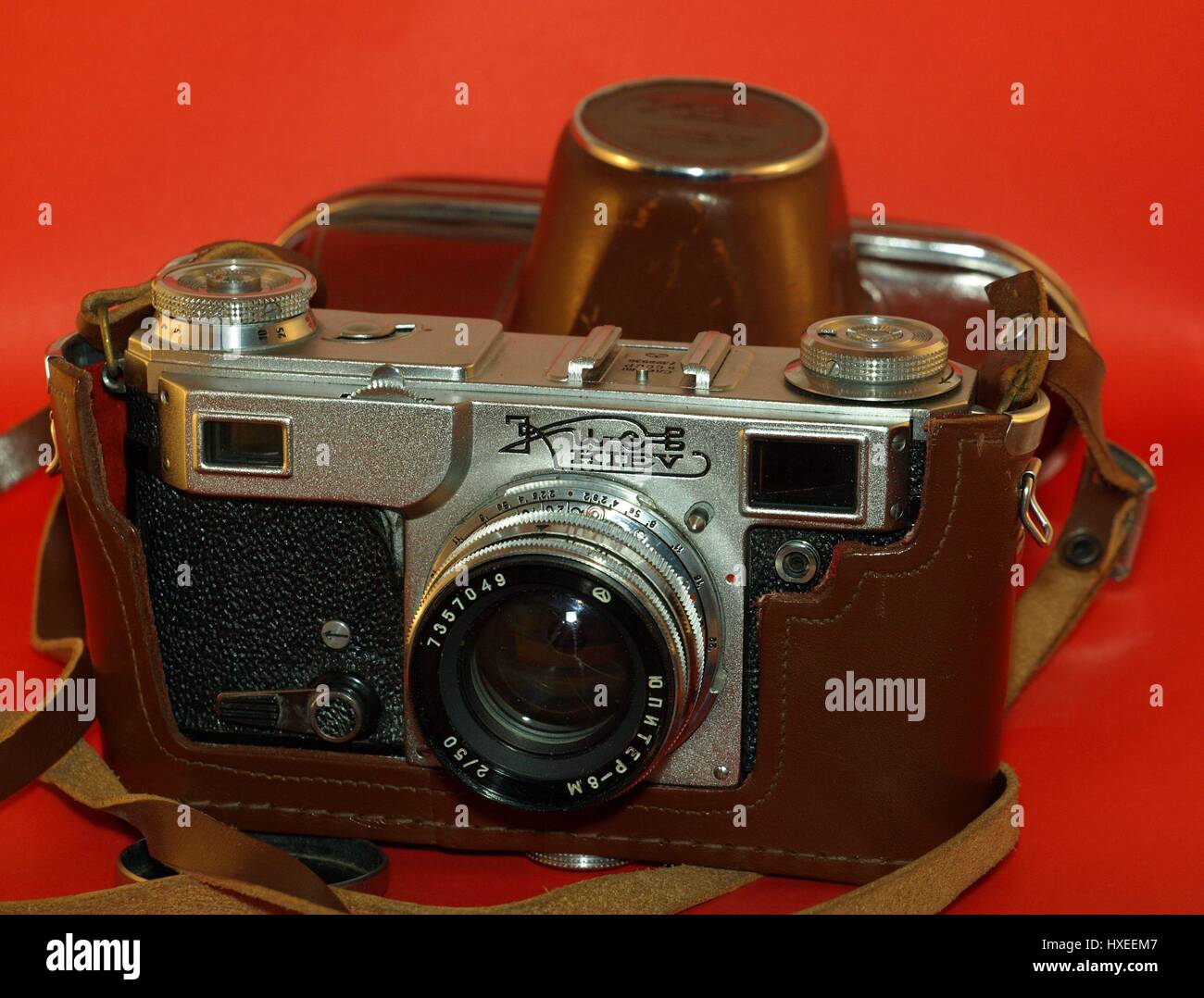 Alte antike Kamera mit Ledertasche auf rotem Grund Stockfoto