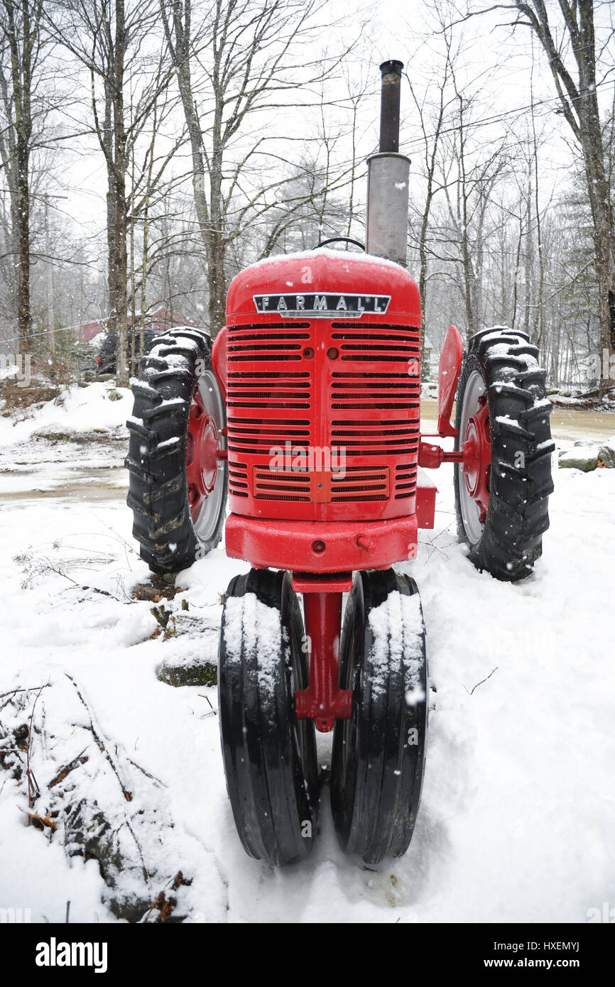 Ein rot Farmall Traktor im Schnee auf einer kleinen Farm in New England Stockfoto