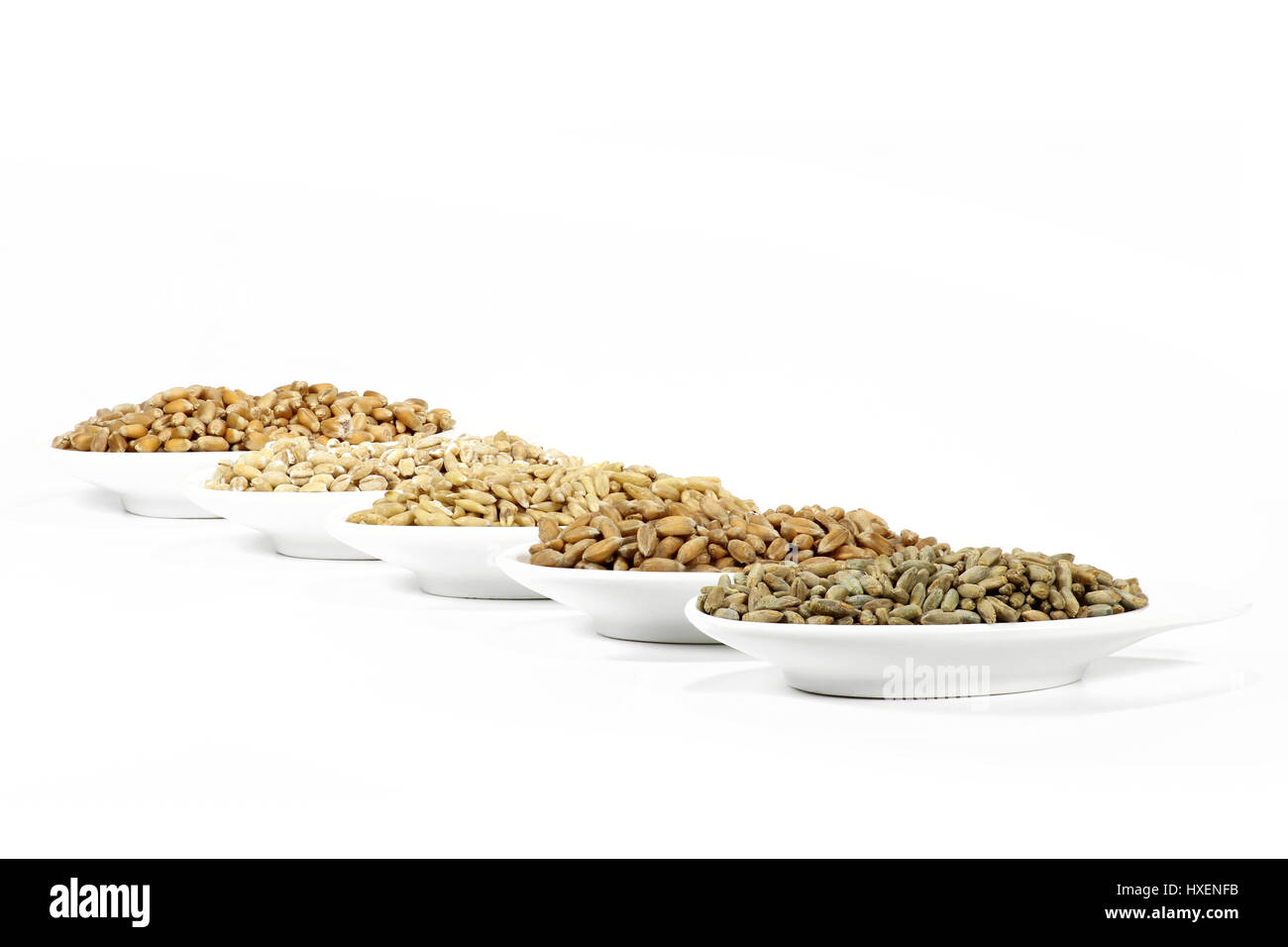 Sortiment von verschiedenen Getreidesorten in Keramikschalen isoliert auf weißem Hintergrund Stockfoto