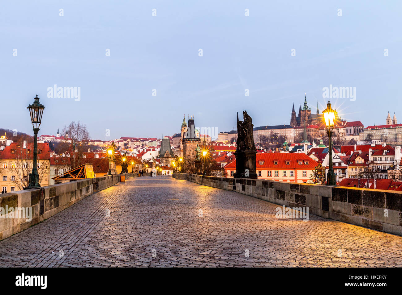 Prag, Tschechische Republik. Karlsbrücke mit der Statue und Sonnenaufgang über der Brücke, Altstädter Brückenturm im Hintergrund. Stockfoto