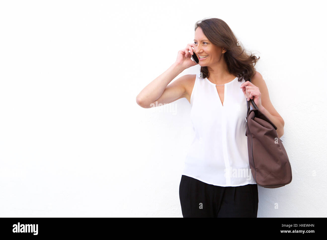 Porträt einer glücklichen Frau mit einem Chat auf dem Handy vor weißem Hintergrund Stockfoto