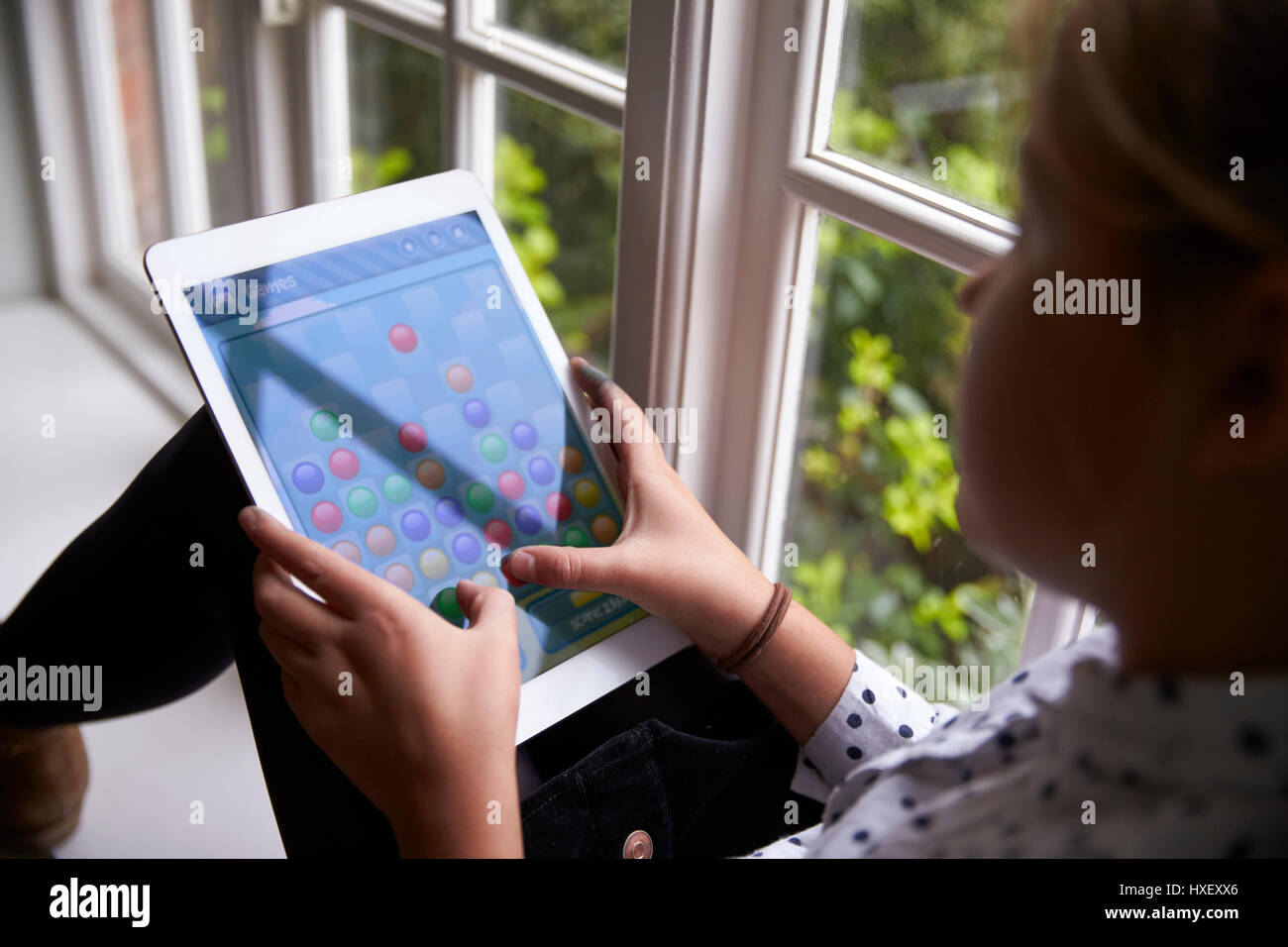 Über die Schulter-Blick des Mädchens Spiel auf digitale Tablet zu Hause Stockfoto