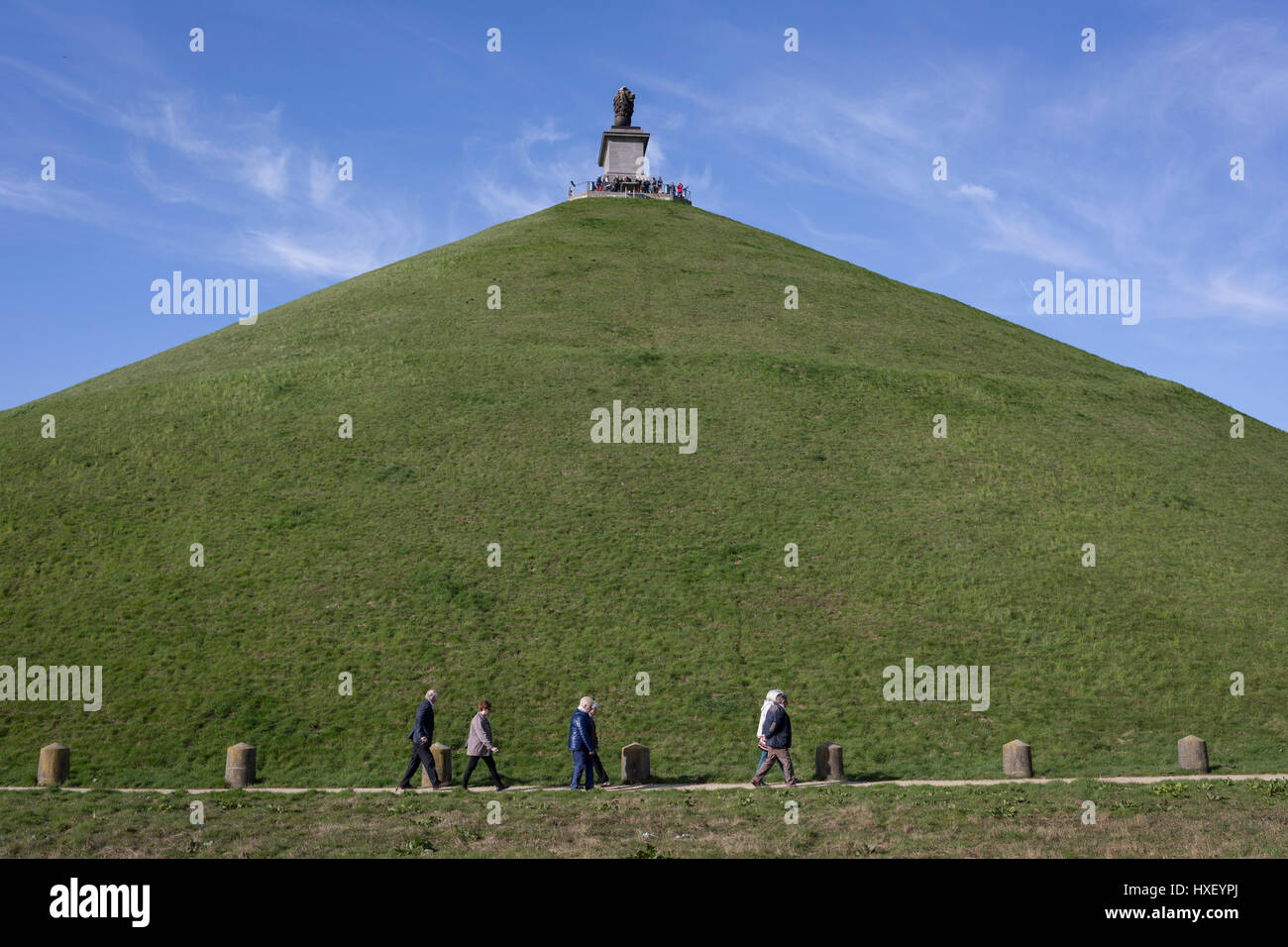 Besucher besichtigen konische 43 Meter hohen Waterloo Lion Schlachtfeld Mound, am 25. März 2017, bei Waterloo, Belgien. Den Löwenhügel (Butte du Lion ist ein großer konische künstliche Hügel, die im Jahre 1826 abgeschlossen. Es erinnert an die Lage auf dem Schlachtfeld von Waterloo, wo eine Muskete Kugel traf die Schulter von William II der Niederlande (Oranien) und schlug ihn von seinem Pferd während der Schlacht. Vom Gipfel bietet des Hügels eine 360-Grad-Aussicht auf das Schlachtfeld. Die Schlacht von Waterloo wurde 18. Juni 1815 gekämpft. Eine französische Armee unter Napoleon Bonaparte unterlag zwei Heere der th Stockfoto