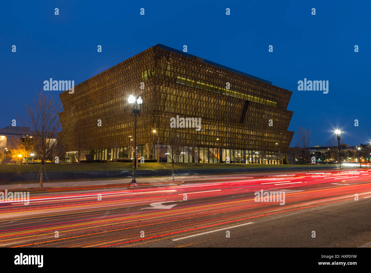 Verkehr schafft Lichtspuren in der Dämmerung außerhalb des Smithsonian National Museum of African American History und Kultur (NMAAHC) in Washington, DC. Stockfoto