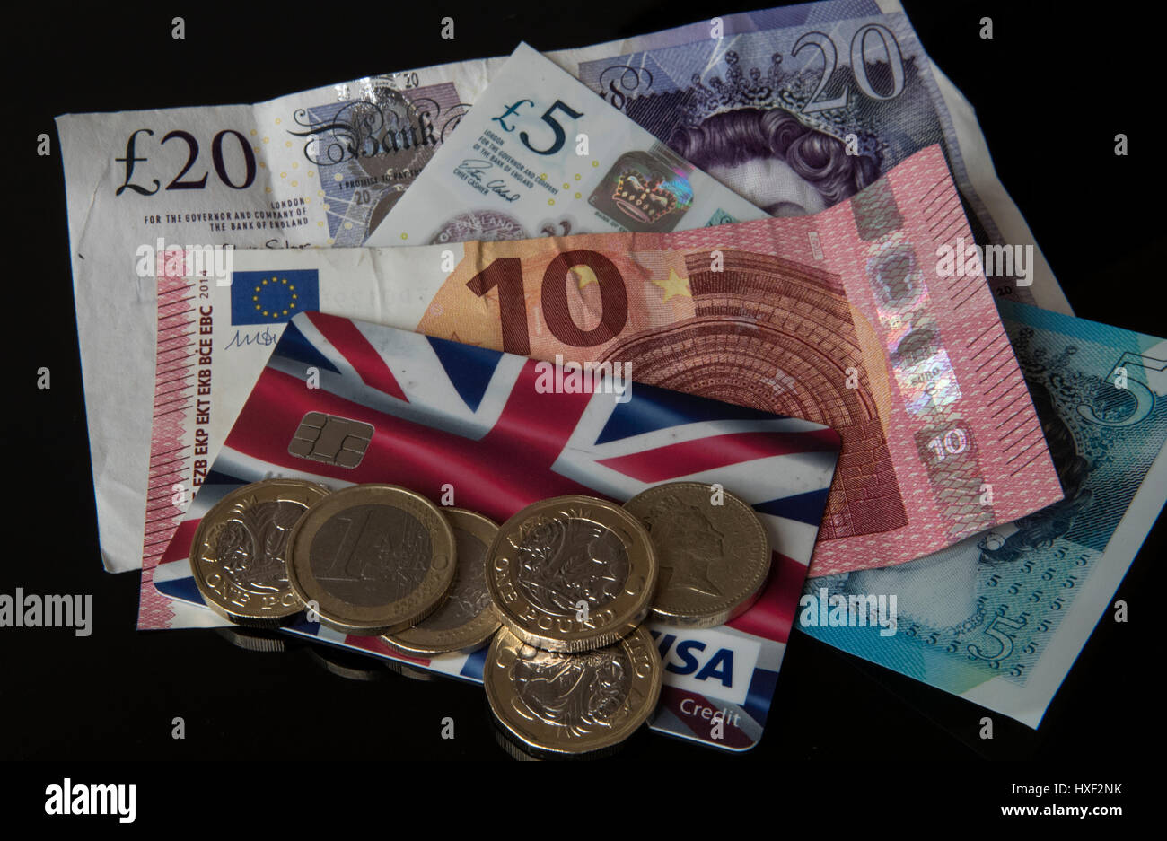Neue 12-seitige £1- und 1-Euro-Münzen auf einer Kreditkarte mit einer neuen £5 Note, £20 Note, 10-Euro-Note in Liverpool, als die neue Pfund-Münze in Umlauf kam - mit frühen Kinderkrankheiten, die an Münzautomaten im ganzen Land zu erwarten waren. Stockfoto