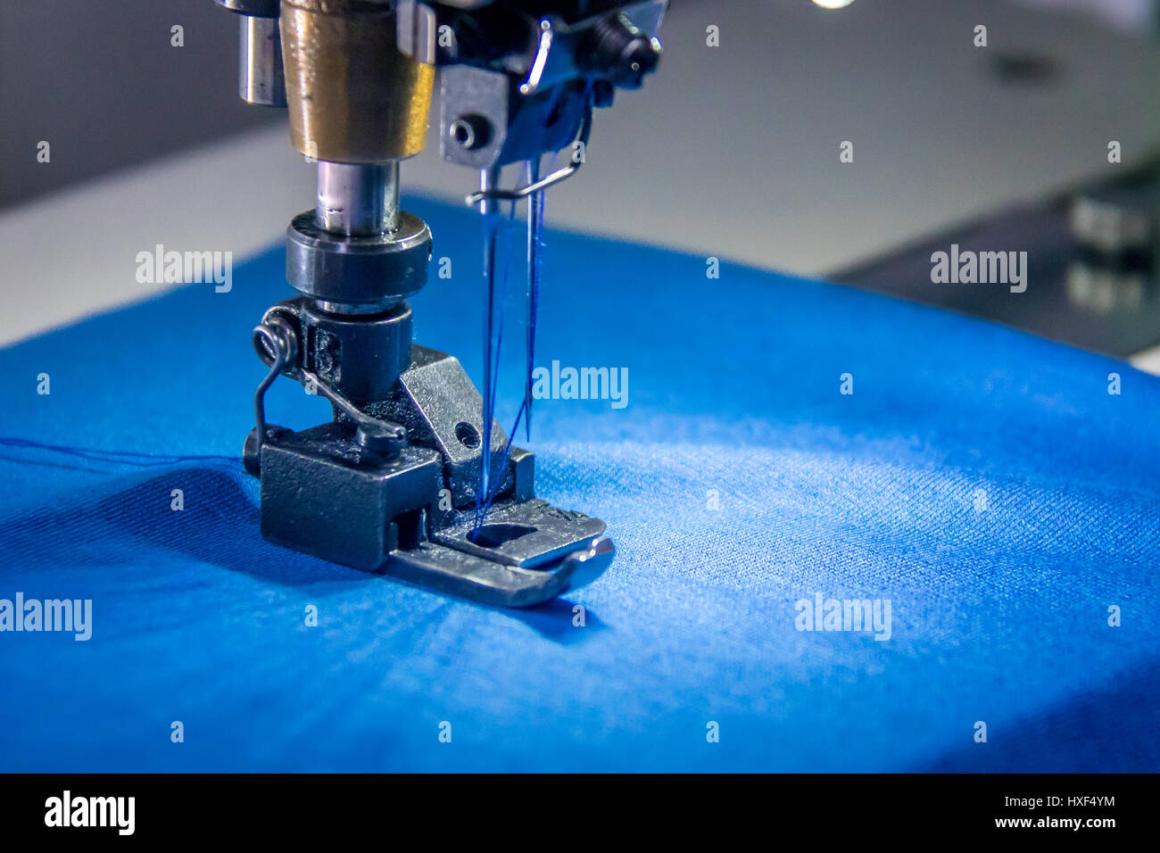 Professionelle Overlock Nähmaschine mit blauem Stoff Stockfoto