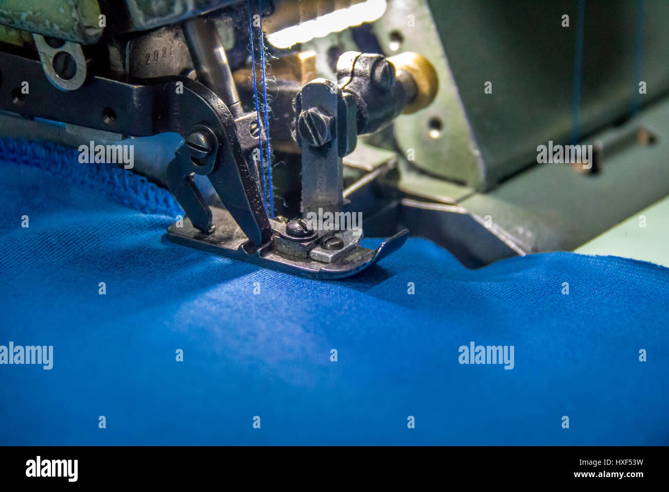 Professionelle Overlock Nähmaschine mit blauem Stoff Stockfoto