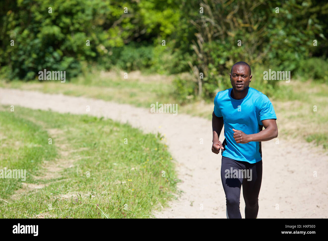 Aktive afroamerikanische Mann läuft auf Pfad im freien Stockfoto