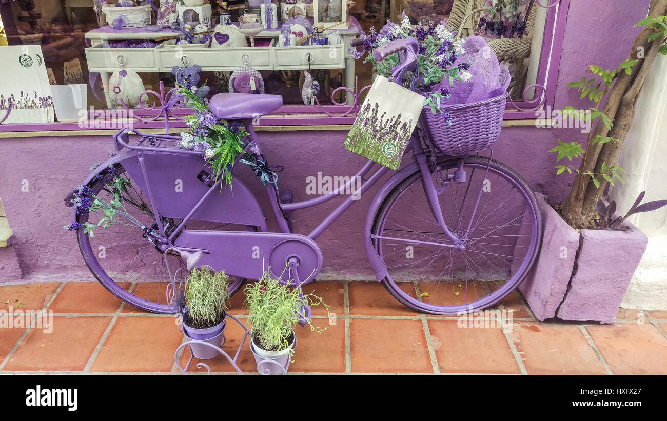 Lavendel-Fahrrad dekoriert mit Zweige Lavendel zu Werbezwecken außerhalb Souvenirladen mit bunten Schaufenster in Spanien. Stockfoto