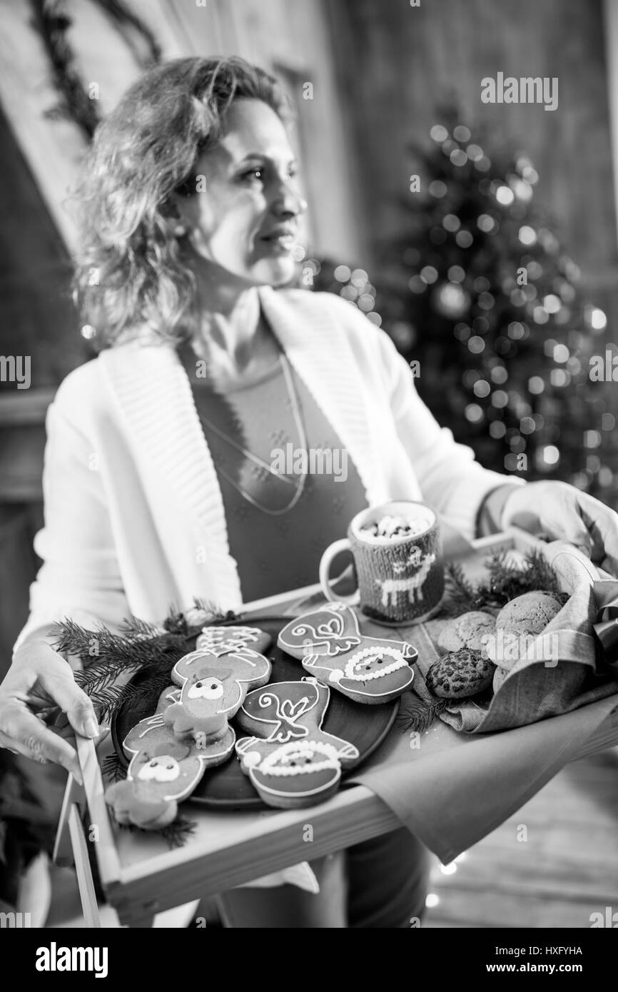 Lächelnde Frau hält Tablett mit Weihnachtsgebäck und schauen Weg, schwarz / weiß Foto Stockfoto
