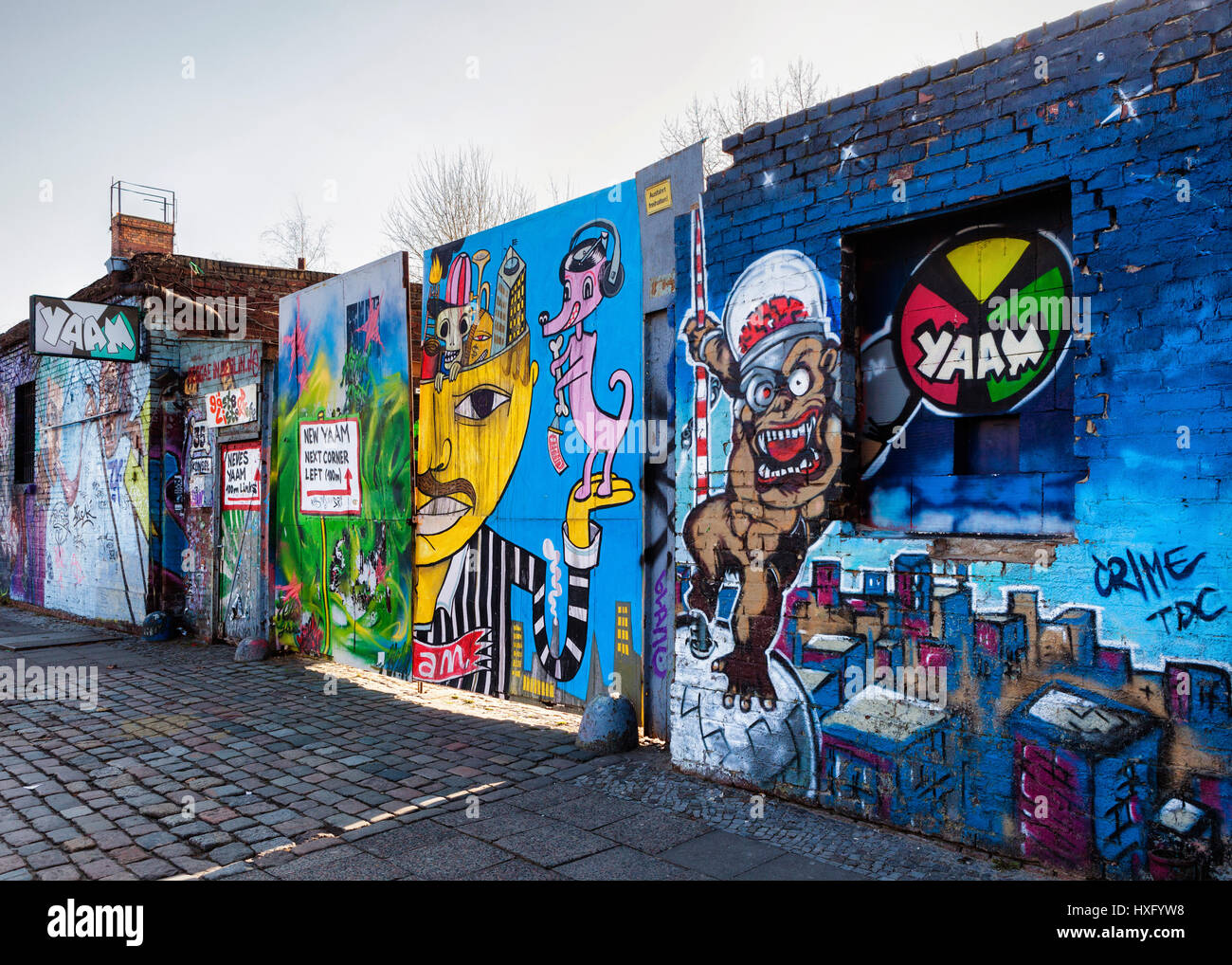 Berlin, Friedrichshain. Alten Eingang zum YAAM, Young African Art Market mit Schild und Wand bedeckt in bunten Streetart Stockfoto