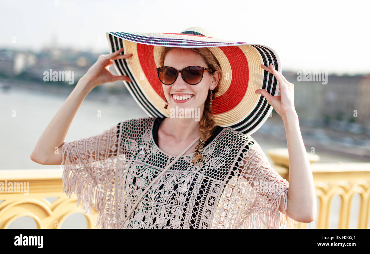 Junge Frau mit Hut am Sommer, der in Sonnenbrille Stockfoto