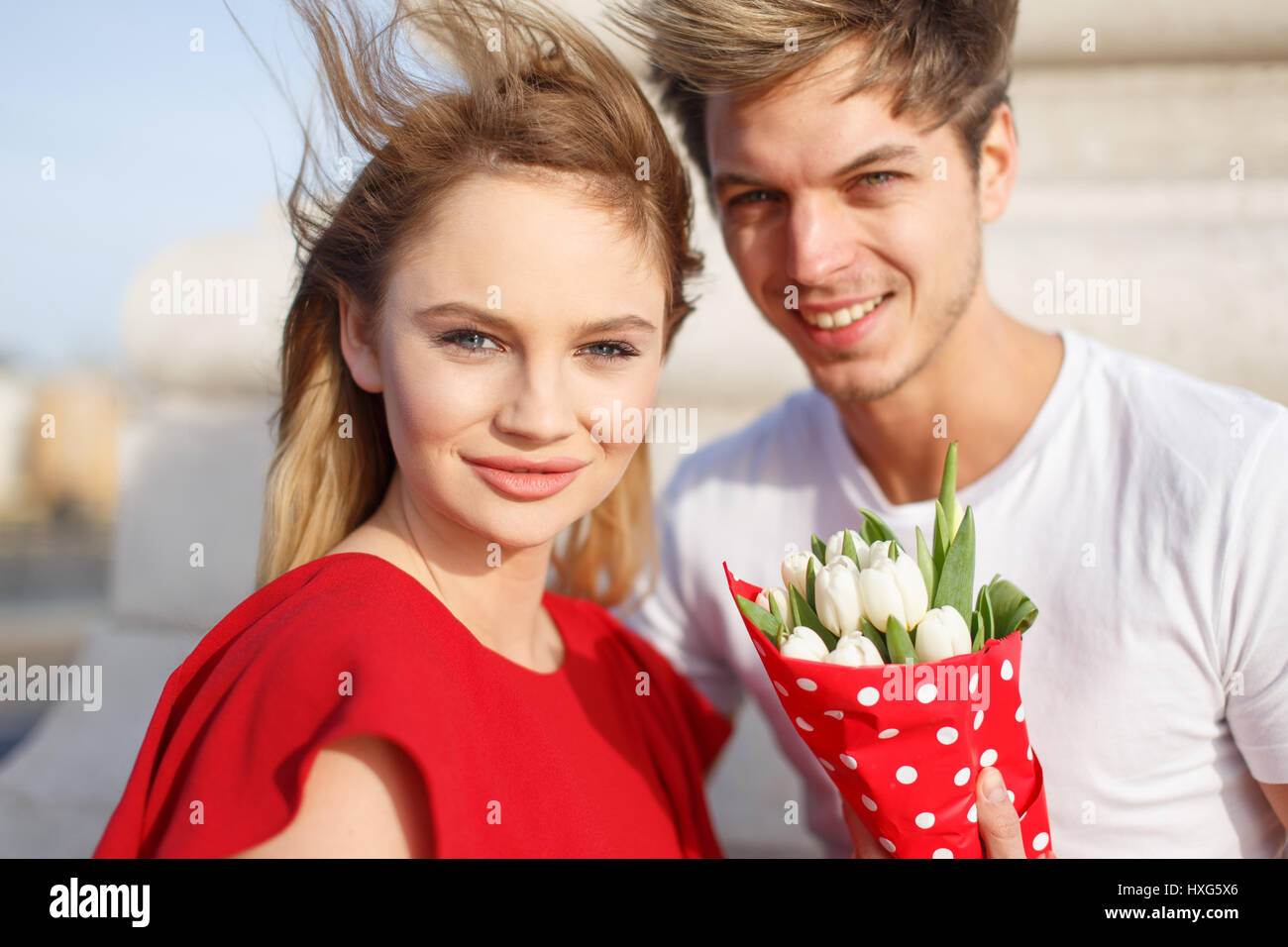 Junge blonde Frau im roten Kleid mit Freund Geburtstag, Stockfoto