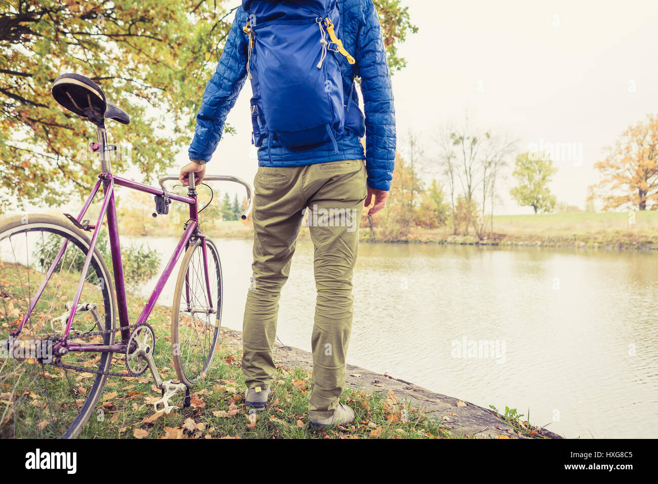 Mann mit Rennrad Blick auf Blick auf den Fluss im Park. Männlichen Pendler und fixed-Gear Fahrrad entspannen im grünen Park. Sport Fitness Motivation und inspiratio Stockfoto