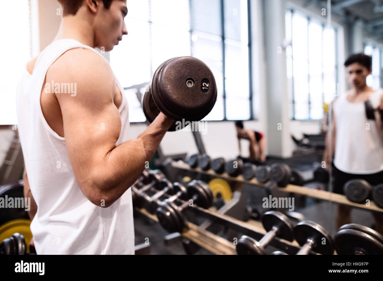 Junge spanische Fitness Mann im Fitness-Studio vor Spiegel, trainieren mit Gewichten Stockfoto