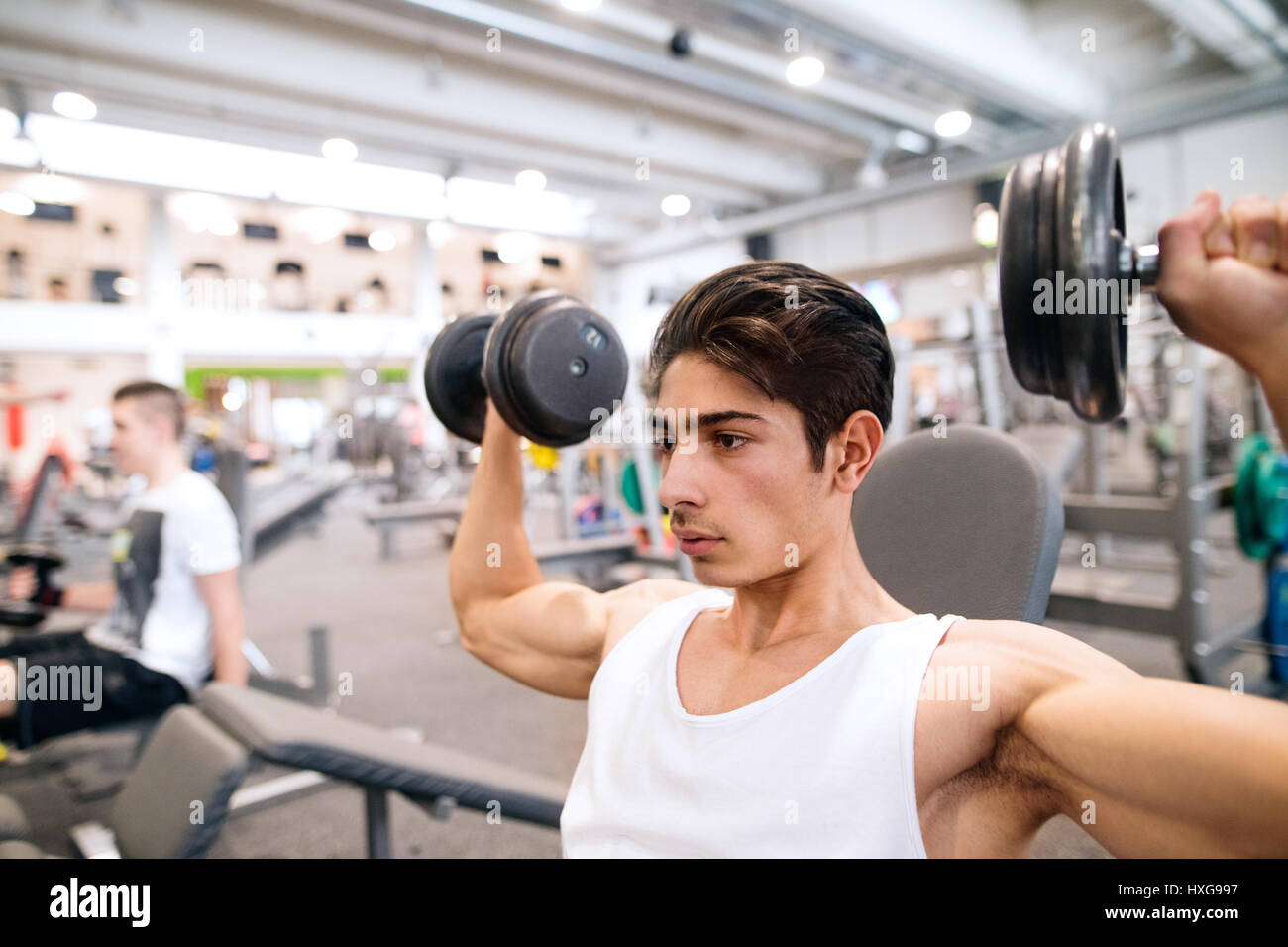 Junge spanische Fitness Mann im Fitnessstudio auf Bank, trainieren mit Gewichten Stockfoto