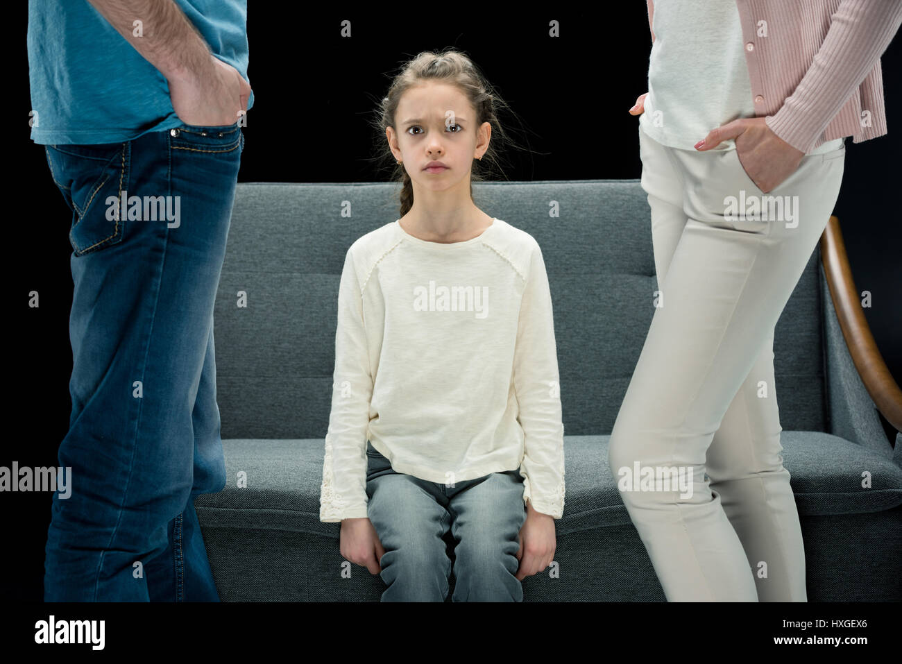 Porträt von unzufriedenen Tochter sitzt auf Sofa mit Eltern in der Nähe von Scheidung-Konzept Stockfoto