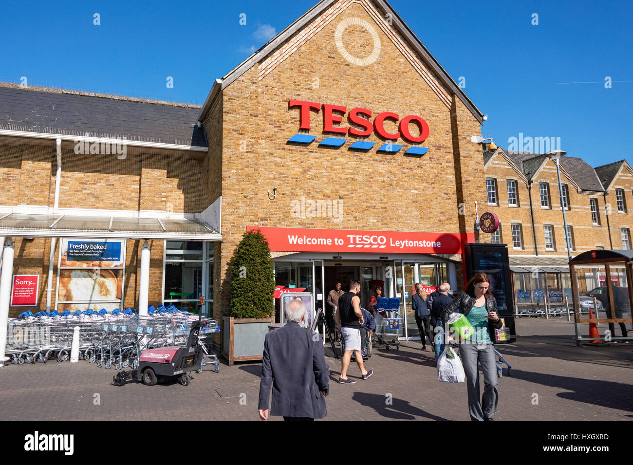 Käufer außerhalb Tesco-Supermarkt in Leytonstone, London England Vereinigtes Königreich UK Stockfoto