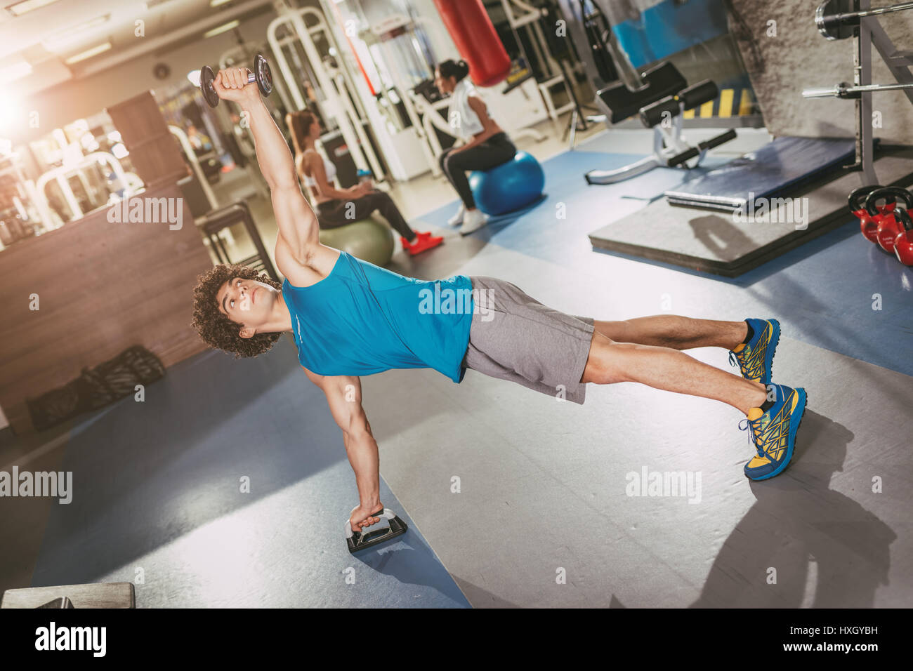 Hübscher junger muskulöser Mann tun Krafttraining im Fitnessstudio. Stockfoto