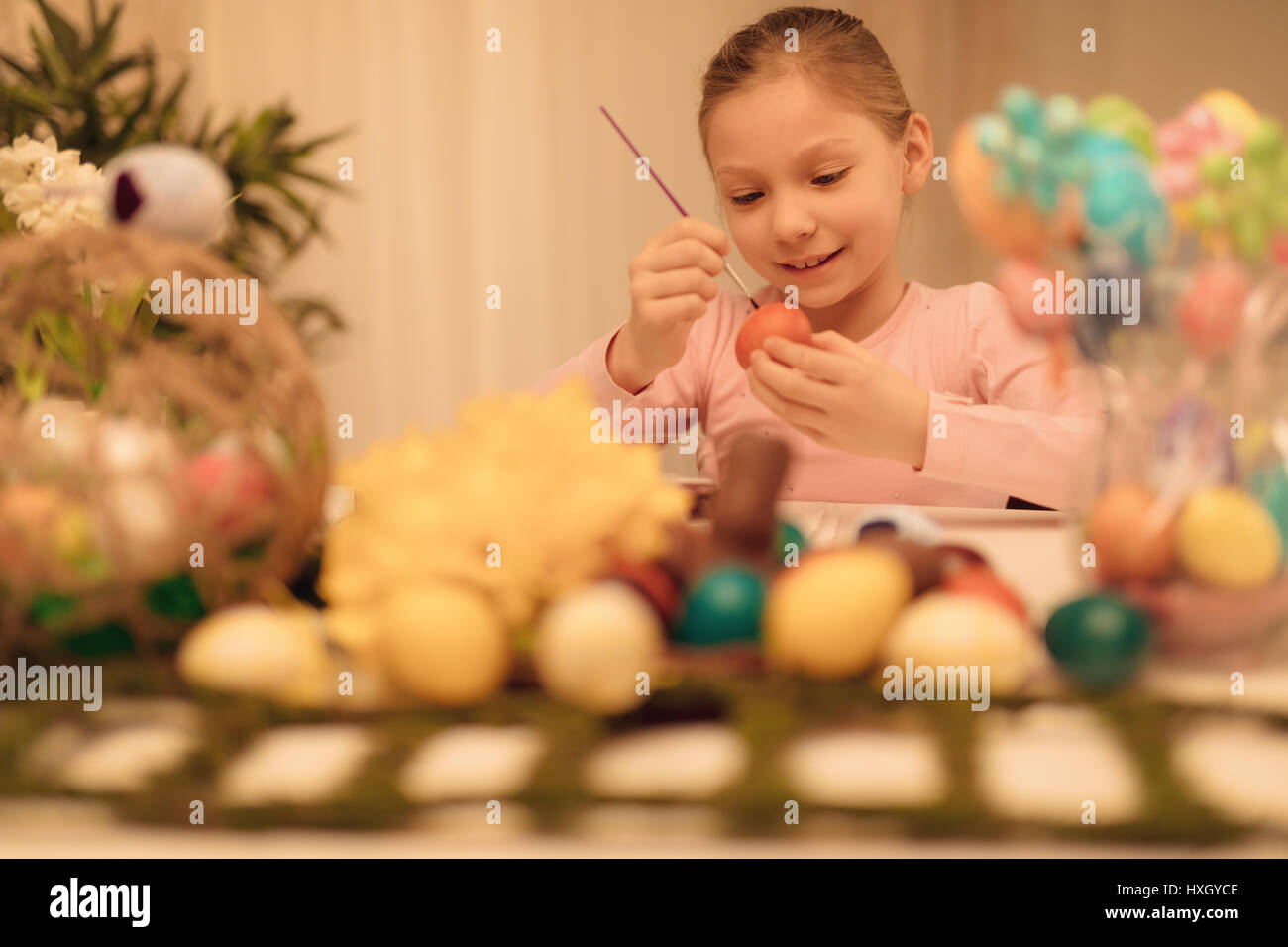Süß lächelnd kleine Mädchen Malerei Osterei zu Hause. Stockfoto