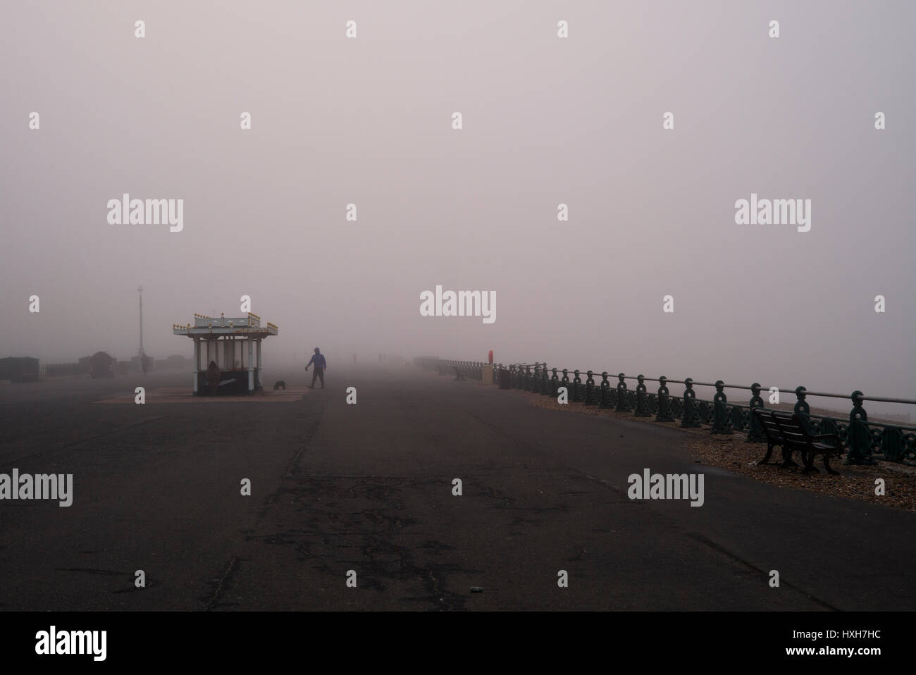 Mann zu Fuß Hund im Nebel, Strandpromenade Stockfoto