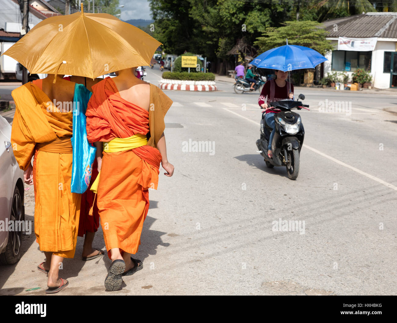 Mönche, die zu Fuß unter der Sonne in Luang Prabang Stockfoto
