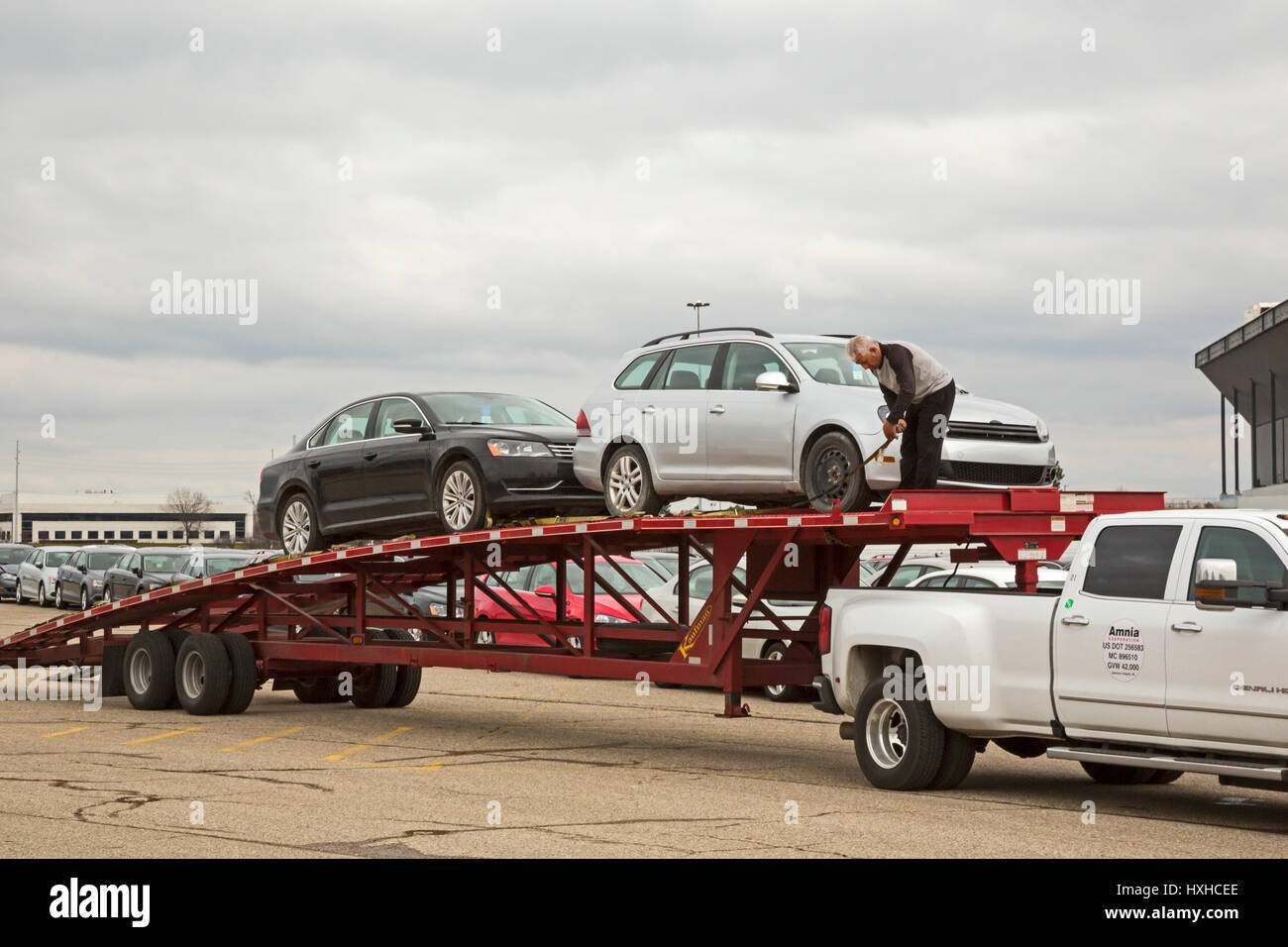 Pontiac, Michigan - ein Arbeiter entlädt einige Tausender von Volkswagen Diesel-Fahrzeuge, die auf den vakanten Pontiac Silverdome geparkt sind. VW kaufte b Stockfoto