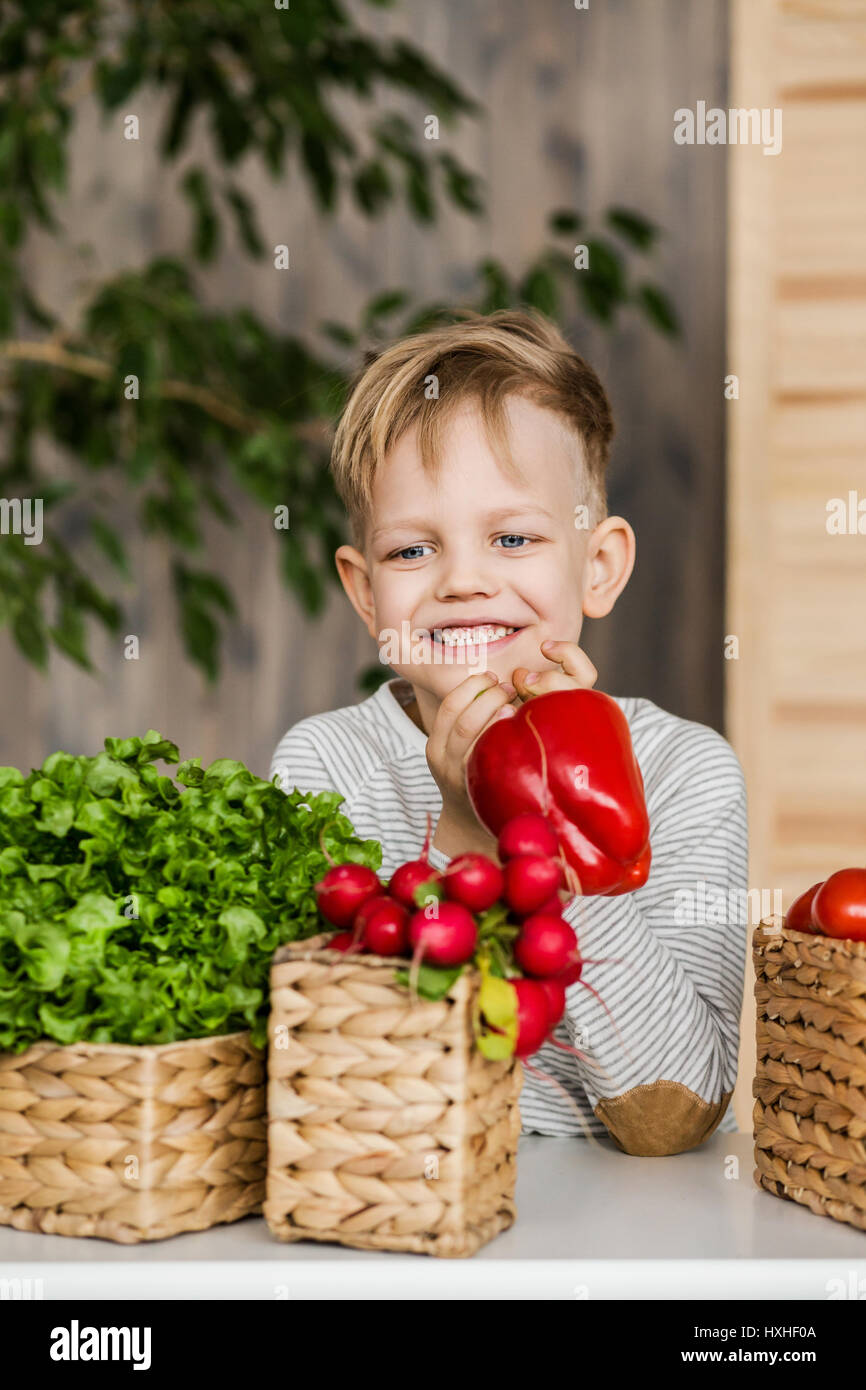 Hübscher kleiner Junge in Küche Gemüse essen. Vegetarier. Gesunde Ernährung Stockfoto