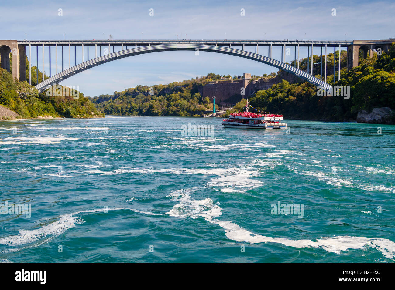 Die Hornblower Boot, Niagara Wonder, voll mit Touristen neben dem kanadischen Wasserfälle und Rainbow Bridge in Niagara, Ontario, Kanada. Stockfoto