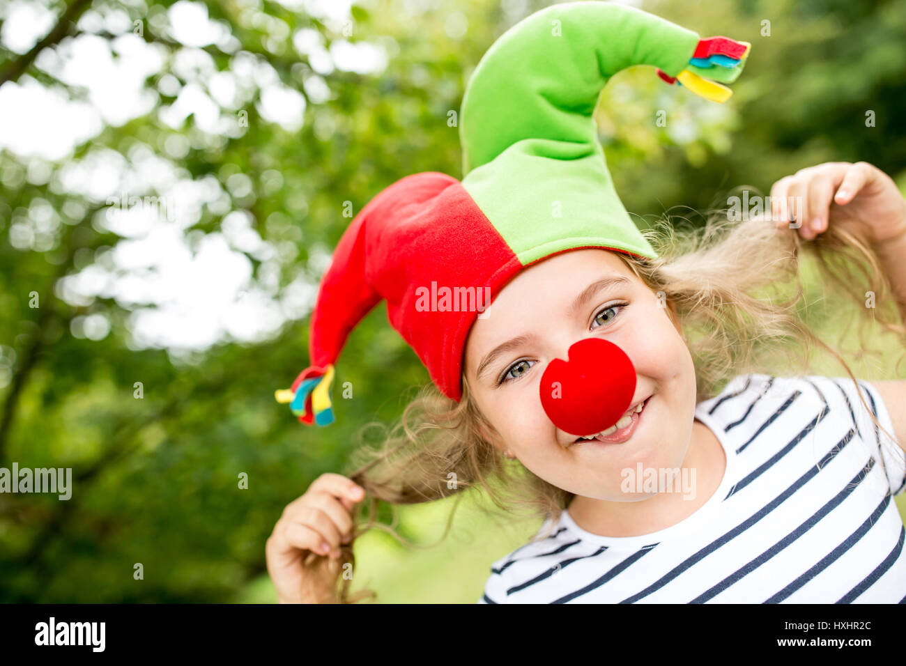 Fröhliches Mädchen als Clown, die Spaß am Kindergeburtstag Stockfoto