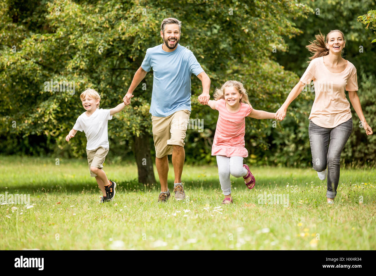 Glückliche Familie mit zwei Kindern zusammen im Frühling im park Stockfoto