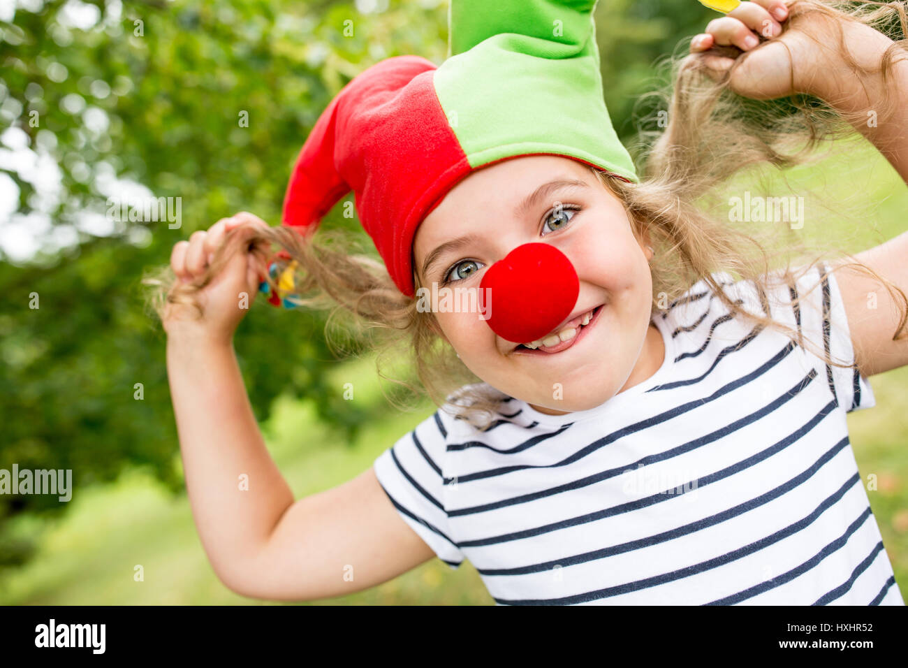 Mädchen im Clownskostüm mit roten Nase Spaß im Karneval Stockfoto