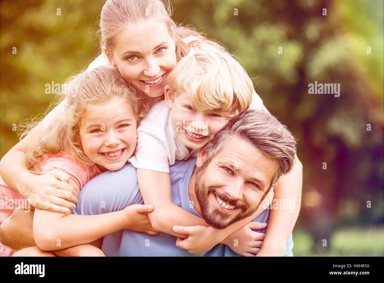 Glückliche Familie mit zwei Kindern in Harmonie in der Natur umarmt Stockfoto