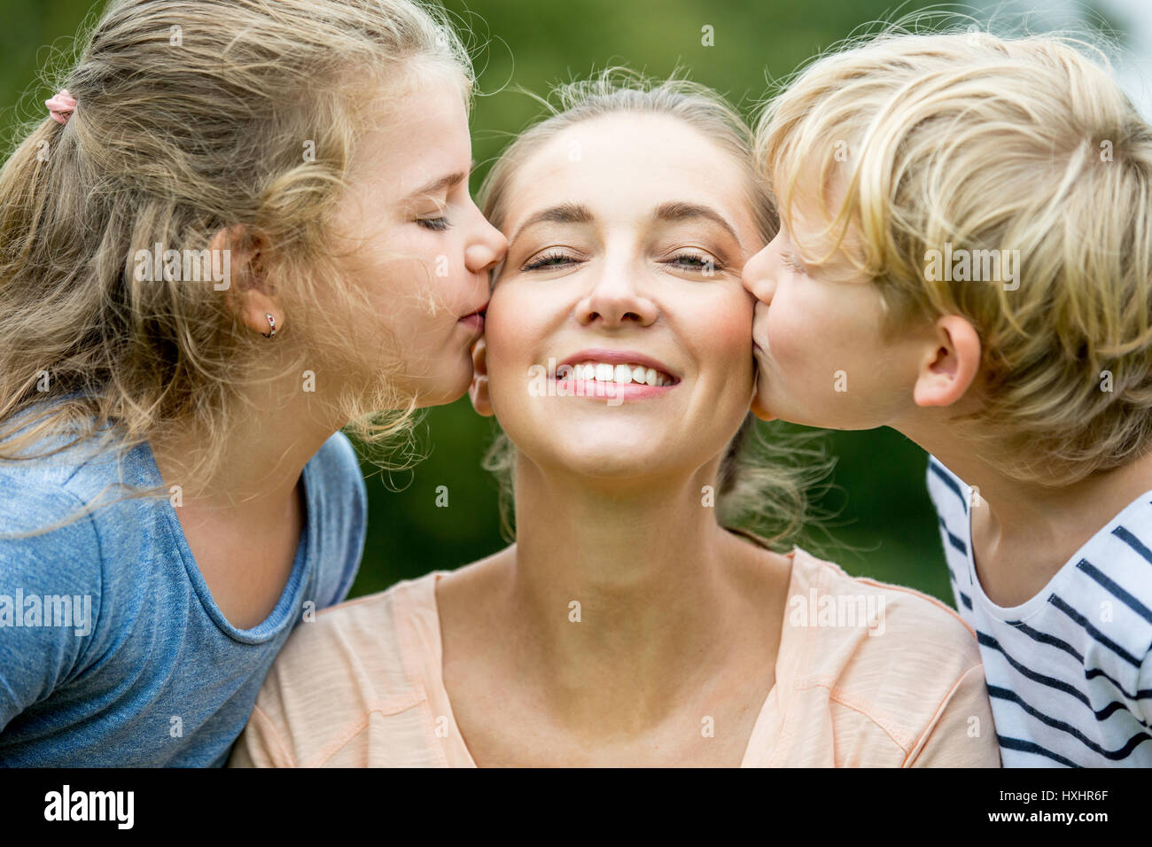 Kinder geben glückliche Mutter einen Kuss mit Liebe Stockfoto