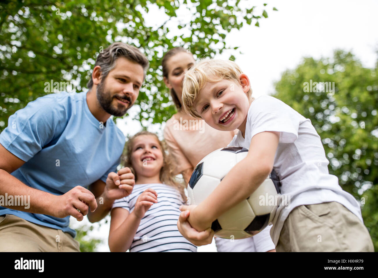 Junge und Familie mit Ball Fußball spielen und Spaß Stockfoto