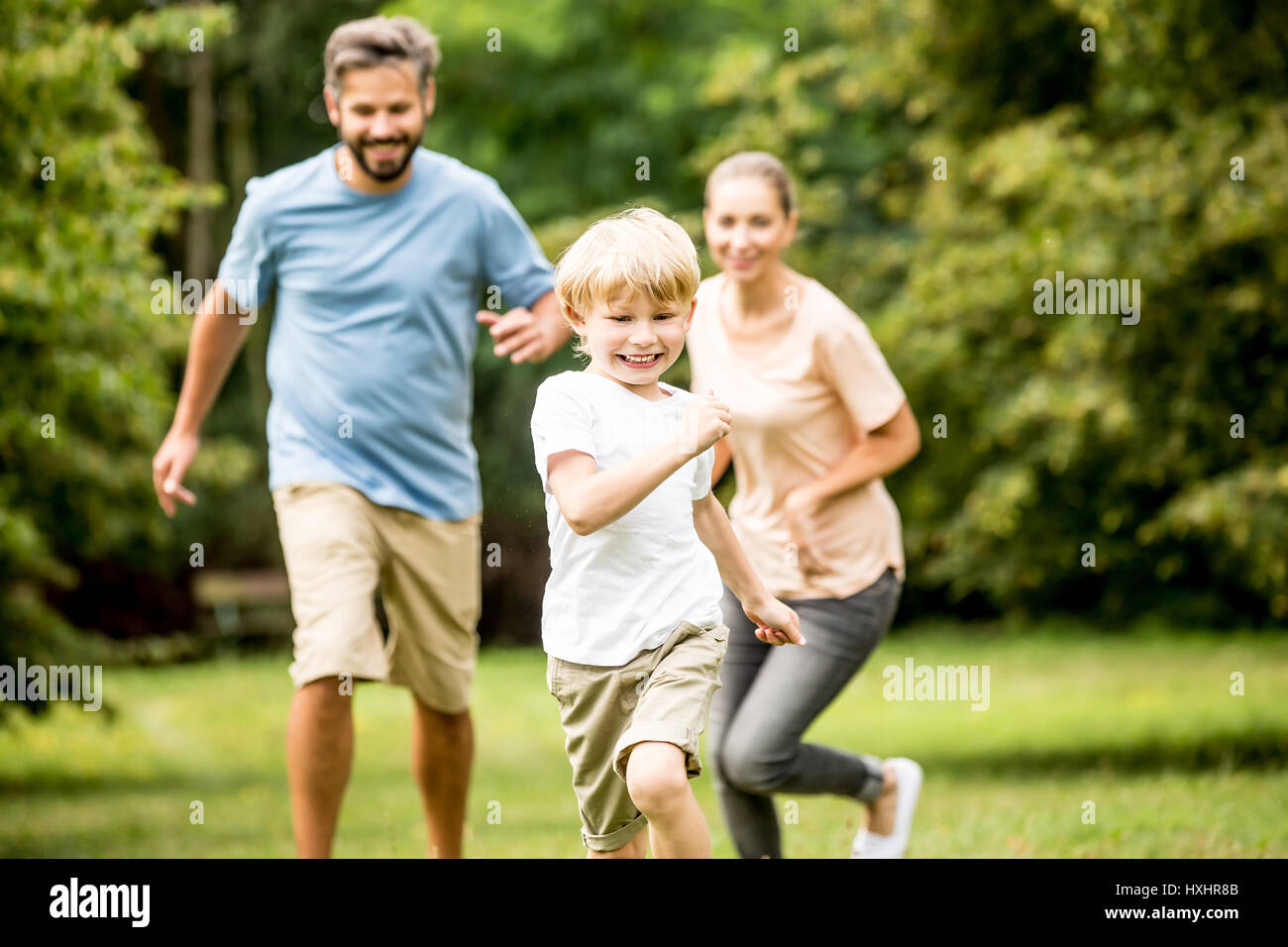 Fröhlicher Junge racing seine Familie und Spaß im Sommer Stockfoto