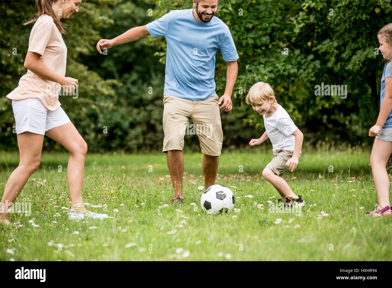 Junge und Familie Fußball spielen und Spaß im Garten Stockfoto