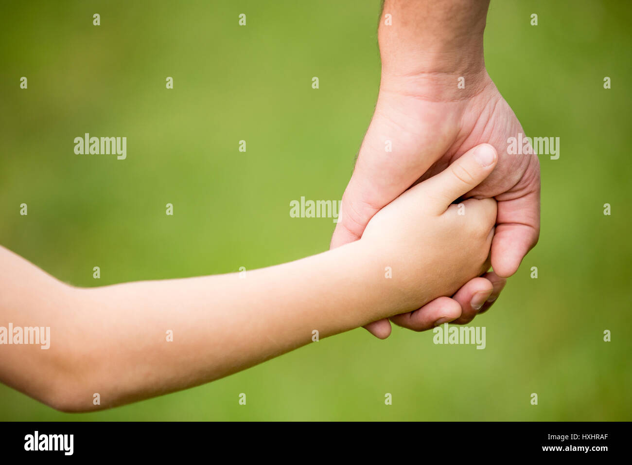 Hände von Vater und Sohn halten sie zusammen als Familie oder Vertrauen Nähe Stockfoto