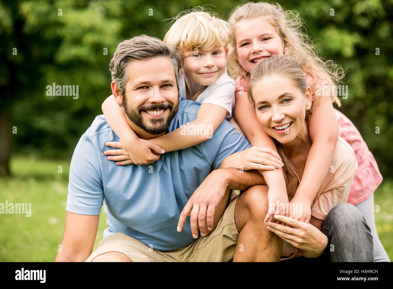 Harmonische Familie mit zwei glückliche Kinder zusammen in eine große Umarmung Stockfoto