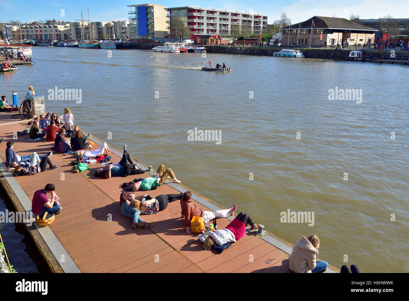 Warmer, sonniger Tag mit Menschen sitzen auf Schwimmdock im Stadtzentrum von Bristol docks Stockfoto