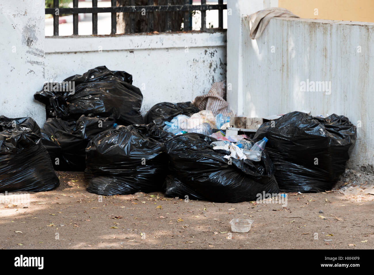 Schwarze Müllsäcke stapelten sich gegen grungy Wand - Dschibuti East Africa Stockfoto