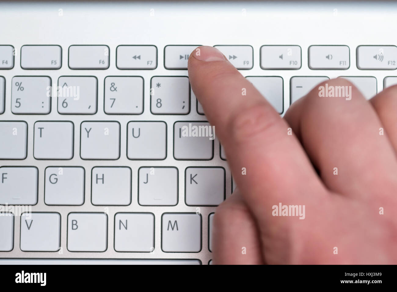 Zeigefinger Pressen die Play Taste auf dem weißen Tastatur, Nahaufnahme,  verschwommen Stockfotografie - Alamy