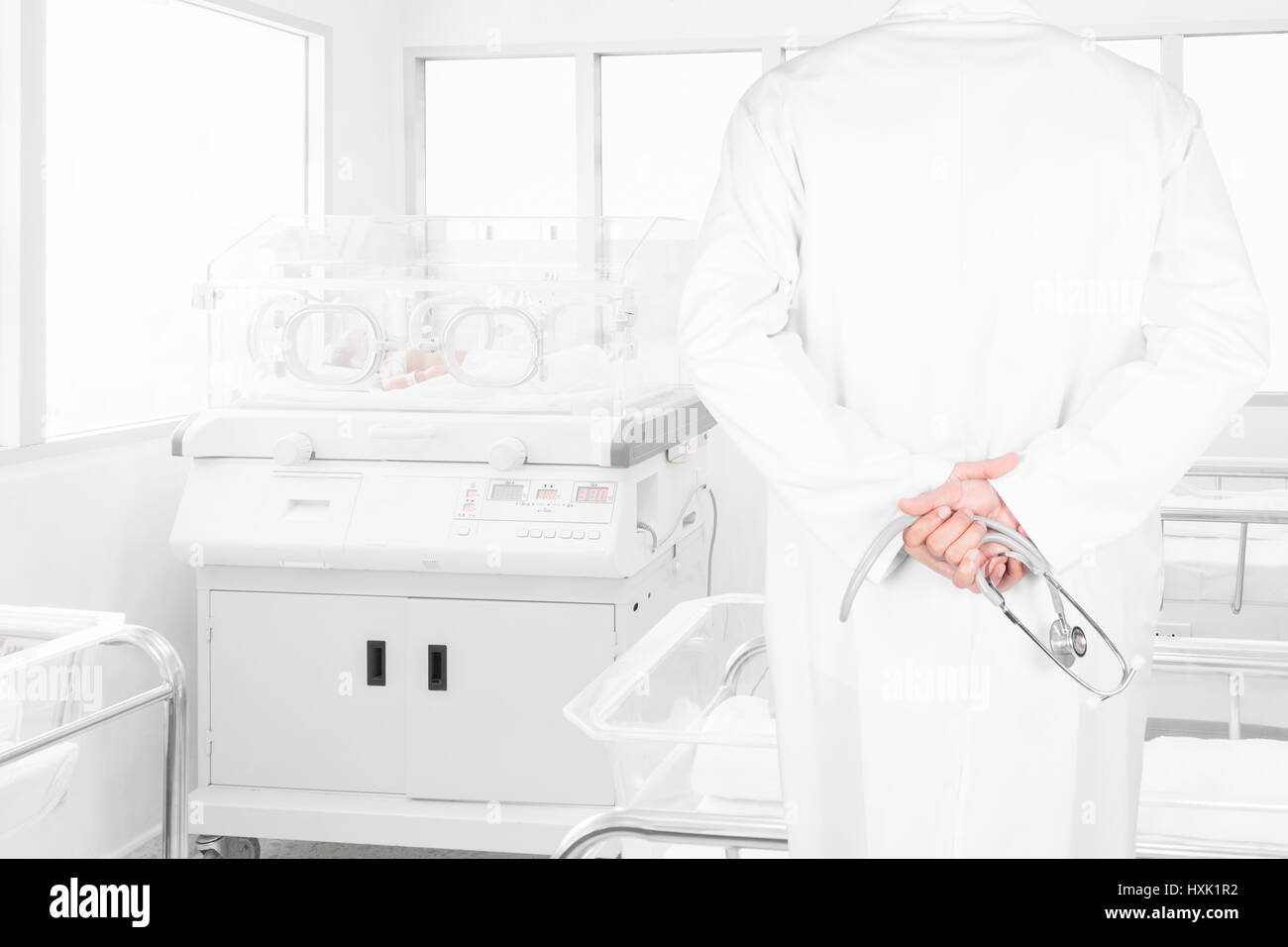 Rückansicht Bild von Ärzten mit Stethoskop Neugeborenen fallen in die Brutmaschine in Krankenzimmer Endfinanzierung zu betrachten Stockfoto
