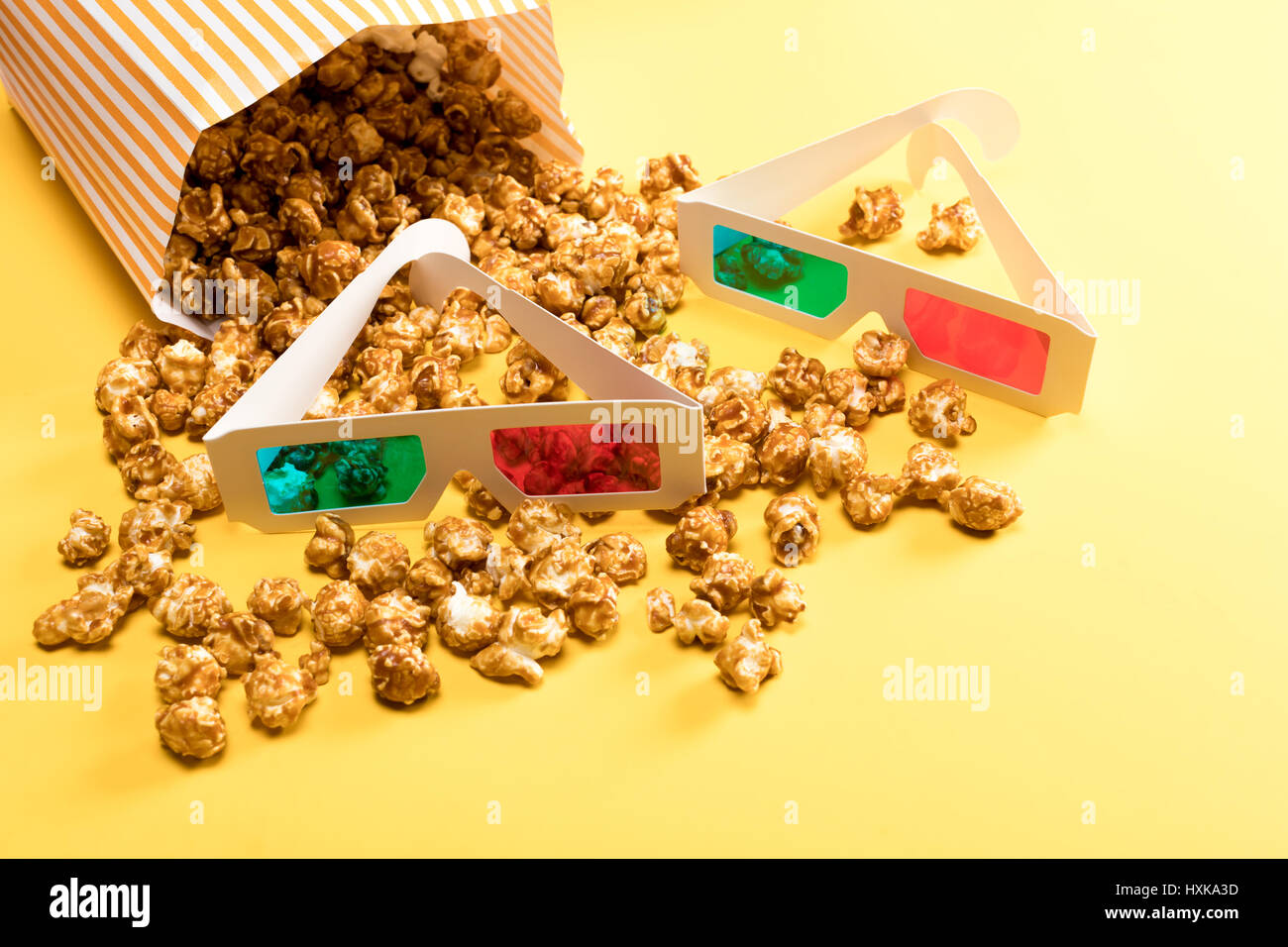 Nahaufnahme von Popcorn und 3D-Brille auf gelb, Film-Zeit-Konzept Stockfoto