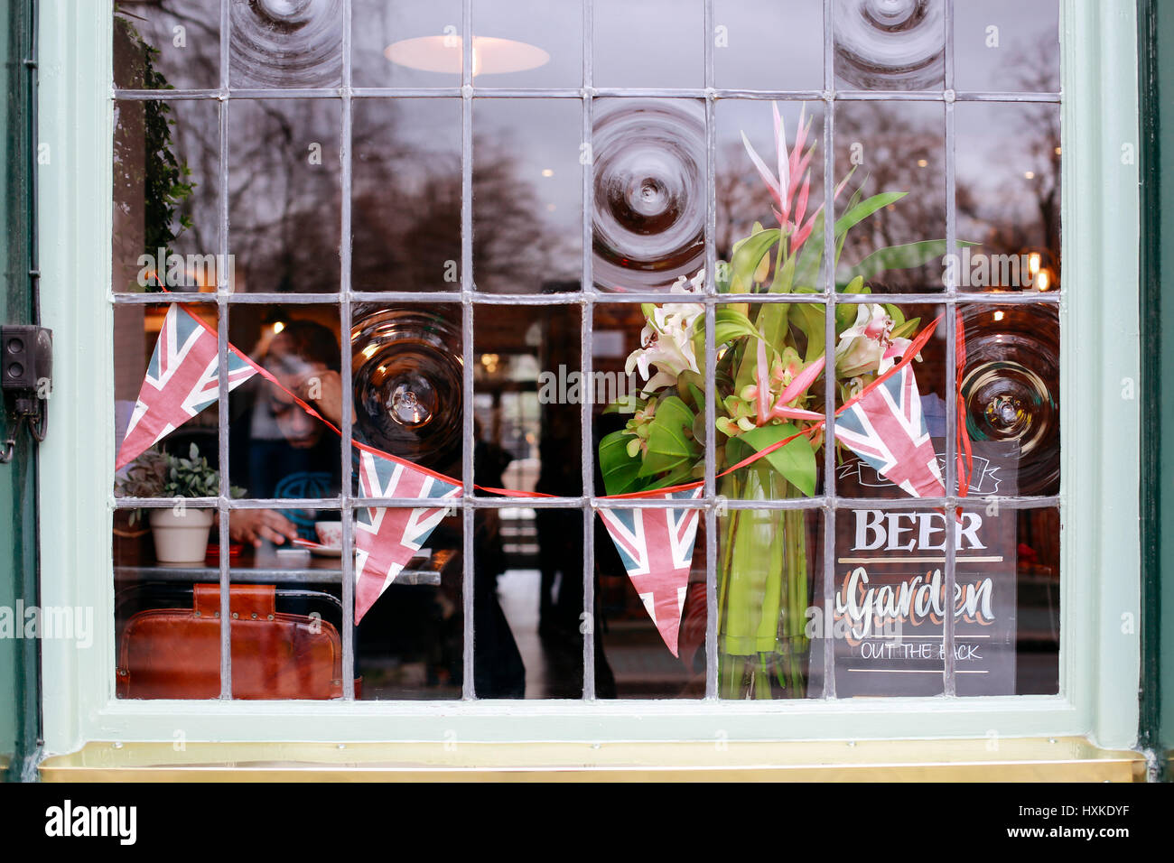 Union Jack Dekoration und Interieur des traditionellen englischen Pub, Blick durch das Fenster von außen. Stockfoto